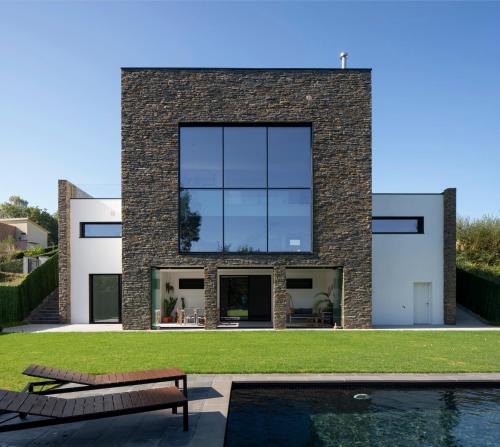 Casa moderna con piscina y vistas al bosque.